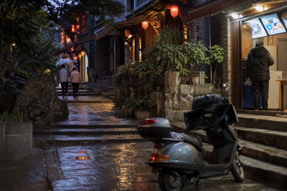 Night street scene in Chongqing with glowing shop signs in Chinese characters