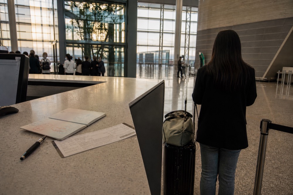 Open passport resting on a boarding pass at a check-in counter