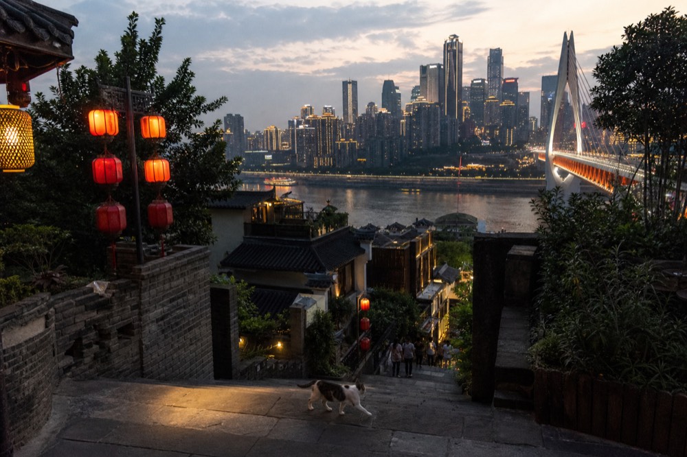 South bank promenade looking across the river at the lit Yuzhong skyline and a bridge