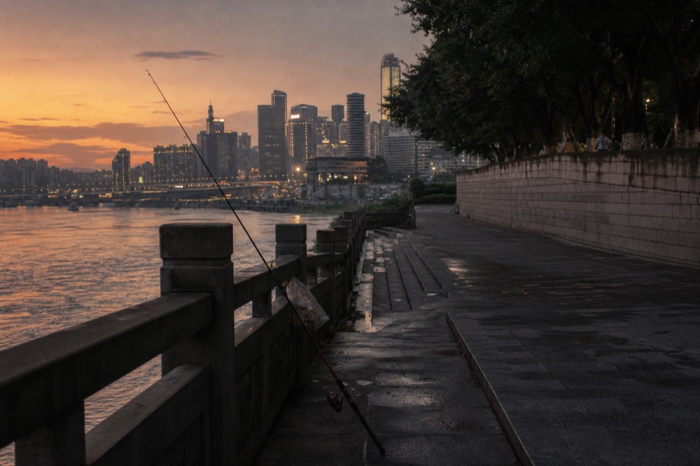 Skyline lights switching on over the river as dusk fades