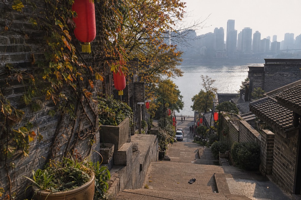 Restored stone terraced street with lanterns and river view on a sunny afternoon